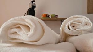 a white blanket on a bed with a bottle of wine at Maré Varna in Varna City