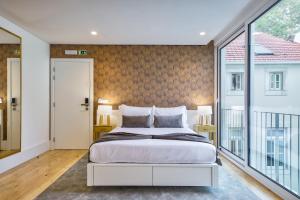 a bedroom with a bed and a large window at Avenue Garden in Coimbra