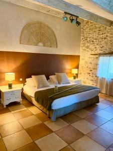a bedroom with a large bed in a room at Restaurant et Chambres d'Hôtes La Ferme de Cornadel in Anduze