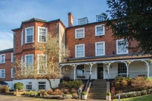 a large red brick building with white windows at Brandshatch Place Hotel & Spa in Dartford