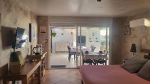 a room with a bed and a dining room with a table at La Picholine in Sorède