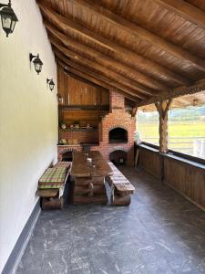 a patio with a table and a brick fireplace at Eva House in Ciocăneşti