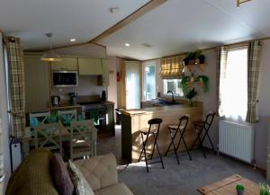 a kitchen and living room with a table and chairs at Cheviot Pines Northumberland in Swarland