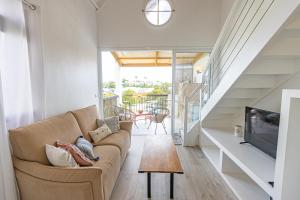 a living room with a couch and a tv at Duplex mezzannine vue marina in Le Gosier