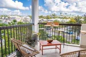 a balcony with chairs and a table and a view of a harbor at Duplex mezzannine vue marina in Le Gosier