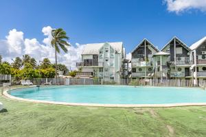 a large swimming pool in front of a building at Duplex mezzannine vue marina in Le Gosier