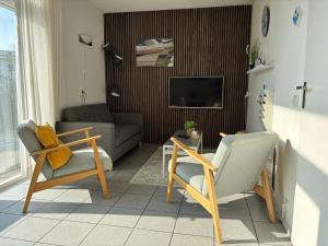 a living room with two chairs and a couch at De Rakken in Woudsend