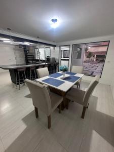 a dining room with a table and chairs and a kitchen at Paraiso Particular Piscina e Ar Condicionado in Americana