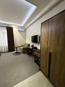 a hotel room with a couch and a television at Loren Hotel in Tashkent