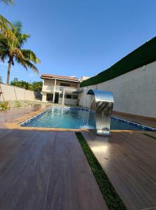 a swimming pool with a water fountain in front of a building at Paraiso Particular Piscina e Ar Condicionado in Americana