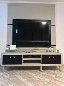 a large entertainment center with a large flat screen tv at Paraiso Particular Piscina e Ar Condicionado in Americana