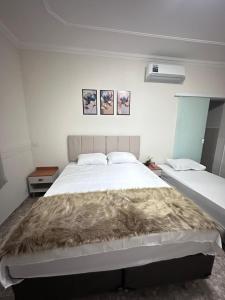 a bedroom with a large bed with a furry blanket on it at Paraiso Particular Piscina e Ar Condicionado in Americana +28 photos