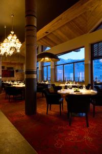 a dining room with tables and chairs and a chandelier at Hôtel Koh-I Nor by Les Etincelles in Val Thorens
