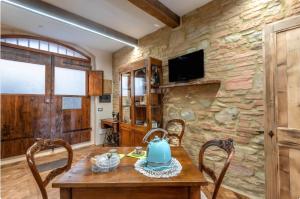 a dining room with a wooden table and a stone wall at Il Girasole -with Garden- in Buonconvento