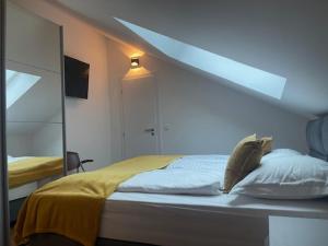 a bedroom with a bed with a yellow blanket and a mirror at BCM Weidinger in Mirce