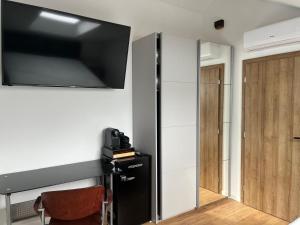 a room with a television on a wall with a chair at BCM Weidinger in Mirce
