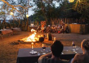 a group of people sitting around a camp fire at Malkoha Lake St Lucia in Hluhluwe +138 photos