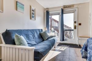 a blue couch in a living room with a balcony at Steps to Sandy Beach! Oceanfront Old Orchard Gem in Old Orchard Beach