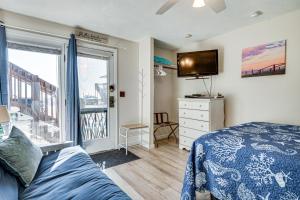 a bedroom with a bed and a tv and a window at Steps to Sandy Beach! Oceanfront Old Orchard Gem in Old Orchard Beach