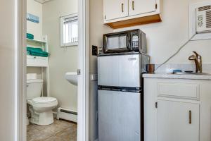 a small kitchen with a microwave on top of a refrigerator at Steps to Sandy Beach! Oceanfront Old Orchard Gem in Old Orchard Beach +16 photos
