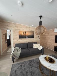 a living room with a couch and a table at Modern VillaJoenhelmi with jacuzzi and sauna in Kuusamo