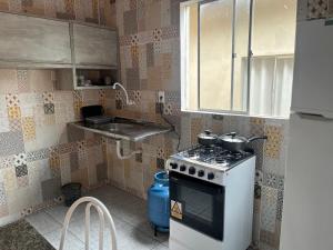 a small kitchen with a stove and a sink at Meu cantinho 5 in Santarém
