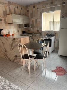 a kitchen with a table and two chairs and a refrigerator at Meu cantinho 5 in Santarém