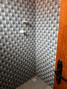 a bathroom with a black and white tiled shower at Meu cantinho 5 in Santarém