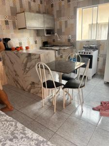 a kitchen with a table and two chairs and a counter at Meu cantinho 5 in Santarém +1 photo