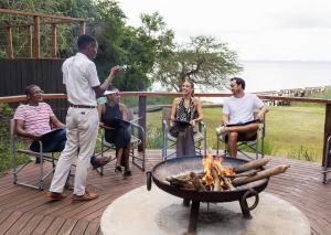 a group of people sitting around a fire pit at Malkoha Lake St Lucia in Hluhluwe