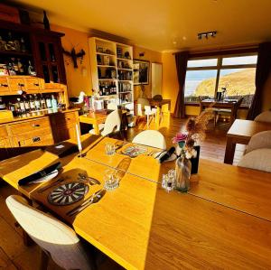 a wooden table in a living room with a dining room at SEAcroft Licensed B&B and Restaurant in Aird Uig