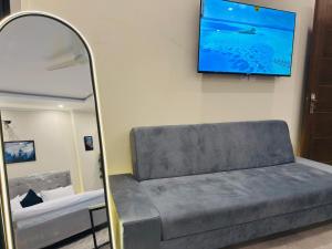 a room with a couch and a tv on a wall at Stay Premium in Islamabad