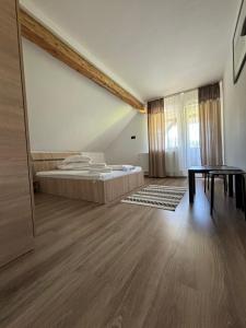 a large bedroom with a bed and a table at Eva House in Ciocăneşti