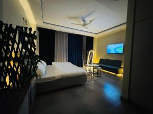 a bedroom with a bed and a couch and a tv at Stay Premium in Islamabad