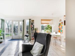 a living room with a chair and a table at Holiday Home Noordwijk near Beach & Sauna in Noordwijk +32 photos