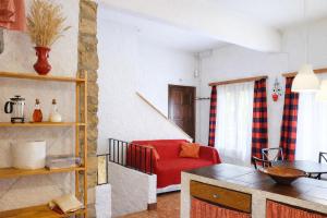 a living room with a red chair and a couch at Casa rural amb cova - Cal Gravat in Montsonis