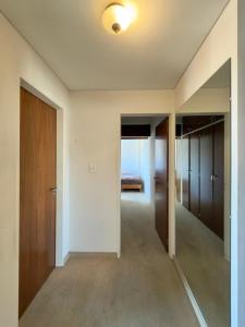 an empty room with a hallway with doors and a bedroom at Departamento Torraca VII in Comodoro Rivadavia