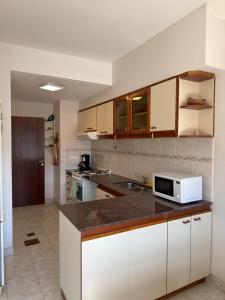 a kitchen with white cabinets and a microwave on a counter at Departamento Torraca VII in Comodoro Rivadavia