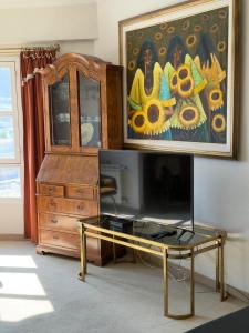 a living room with a tv and a painting on the wall at Departamento Torraca VII in Comodoro Rivadavia