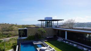 a house with a swimming pool and a water tower at Truntum Boutique Mandalika in Kuta Lombok