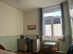 a small kitchen with a table and a window at Coquelicot in Armentières
