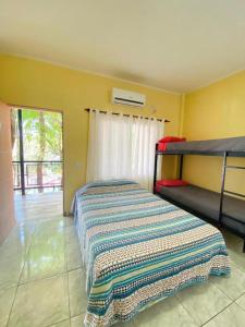 a bedroom with a bed with a blanket on it at Hostel Park Iguazu in Puerto Iguazú +116 photos