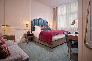 a hotel room with a bed and a couch at The Bedford Hotel Belfast in Belfast