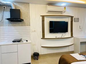 a living room with a tv and a room with a bed at The Starfish Studio in Dehradun