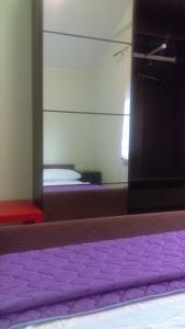 Apartment Frane Grobnik في Dražice: غرفة نوم مع سرير أرجواني ومرآة