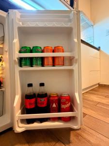 an open refrigerator filled with cans of soda at Espacios Plaza VM in Villa María
