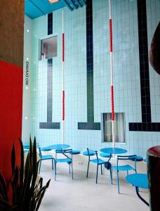 a group of blue tables and chairs in a room at Hotel Not Hotel Rotterdam in Rotterdam