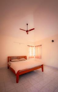 a bed in a room with a ceiling fan at Auralis Experience in Jigani