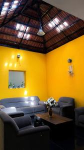 a room with couches and a table and a yellow wall at Auralis Experience in Jigani