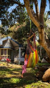 a colorful hammock hanging from a tree in front of a house at Auralis Experience in Jigani +12 photos